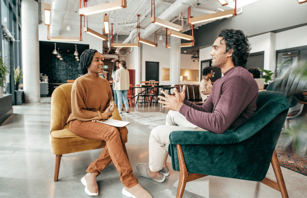 Leadership Qualities: Two coworkers sitting in armchairs talking