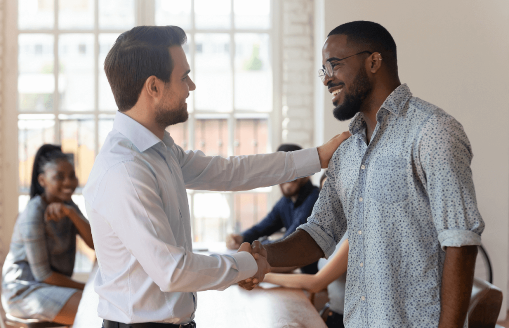 Leadership Qualities: Two colleagues shaking hands and celebrating