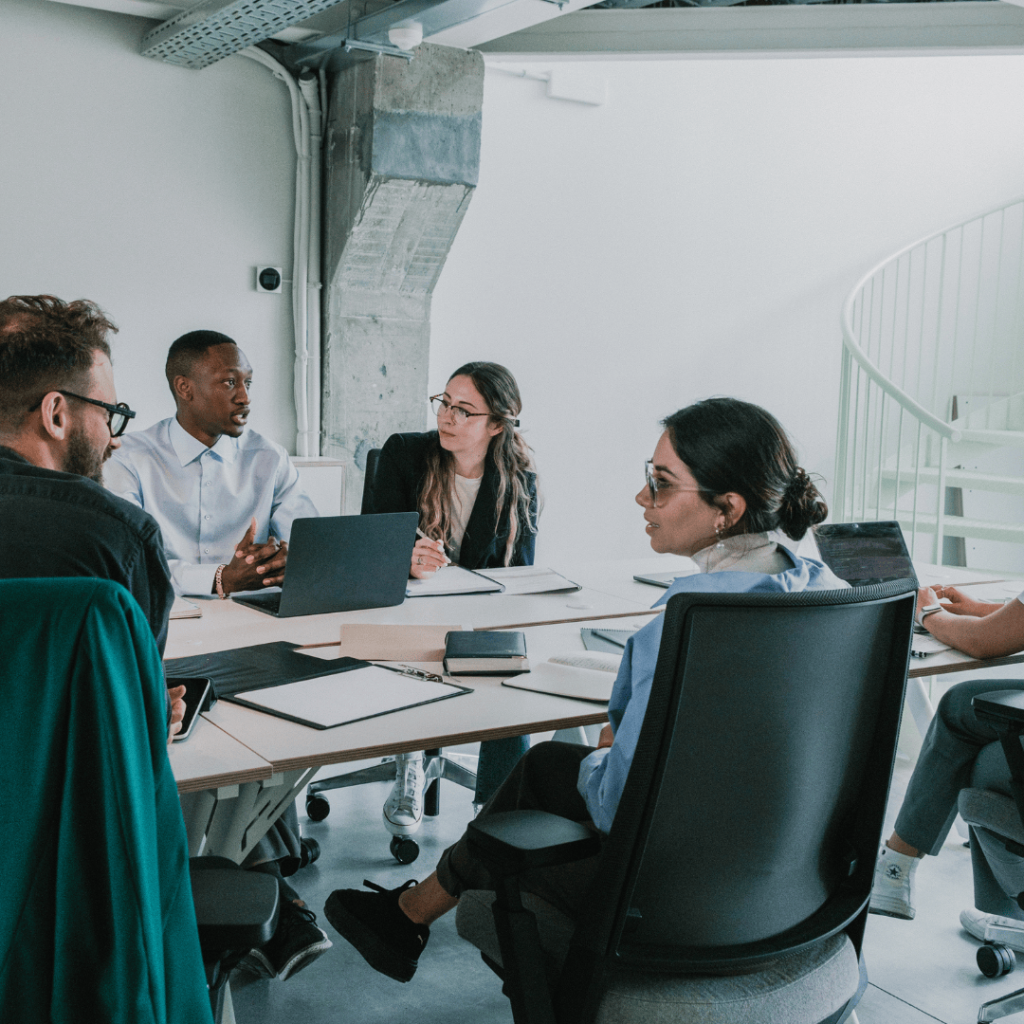 People sat discussing work around a large desk